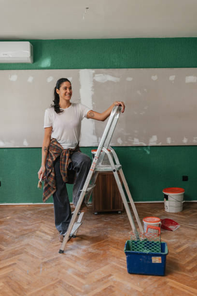 istock Woman Climbing Ladder to Paint a Room 2199344939
