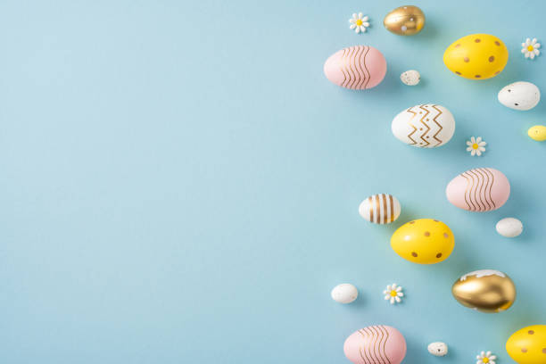 istock Festive flat lay of colorful painted Easter eggs and small daisies over a soft pastel blue surface, perfect for seasonal greetings and spring celebrations 2199347812