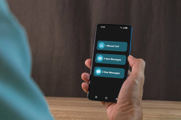 istock Man holding a smartphone with missed call and new message notification on the phone screen 2199349249