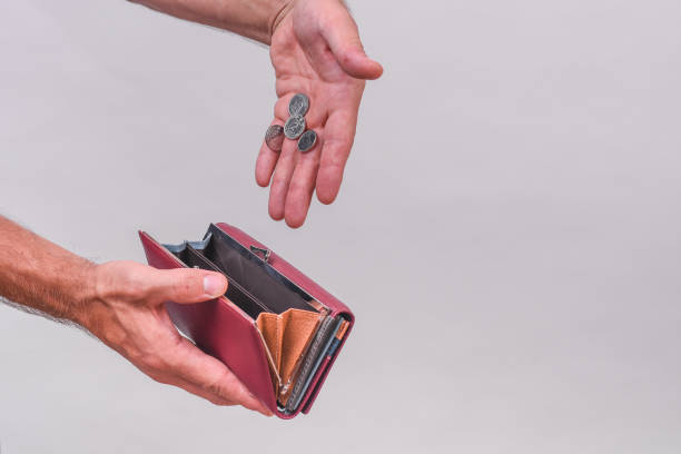 istock A man's hand puts coins in a wallet. 2199349555
