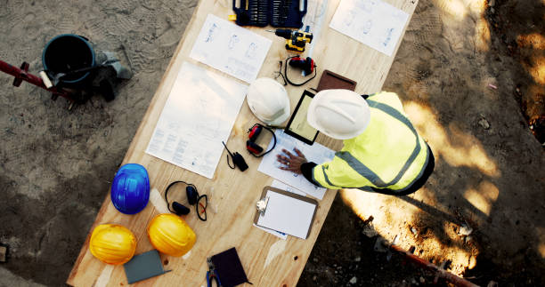 istock Blueprint, construction and man at table with layout, tablet or inspection paperwork from above. Architecture, building project management and contractor with floor plan, digital app and site safety 2199350991
