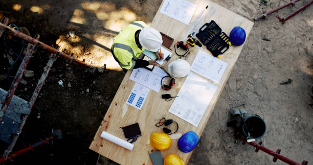 istock Blueprint, architecture and man at table with clipboard, layout and inspection paperwork from above. Construction, building project and contractor with floor plan, checklist or site safety management 2199351002