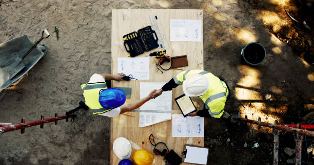 istock Blueprint, construction and men at table shaking hands with collaboration, agreement and inspection from above. Architect, building manager and contractor on site with floor plan, handshake and deal 2199351004
