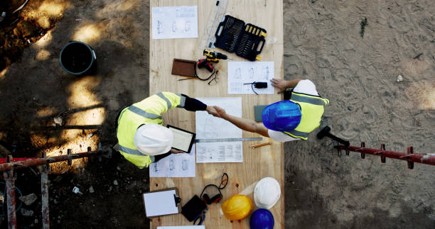 istock Blueprint, construction and men at table with handshake, collaboration and inspection agreement from above. Architect, building team and contractor shaking hands with floor plan, partnership and deal 2199351009