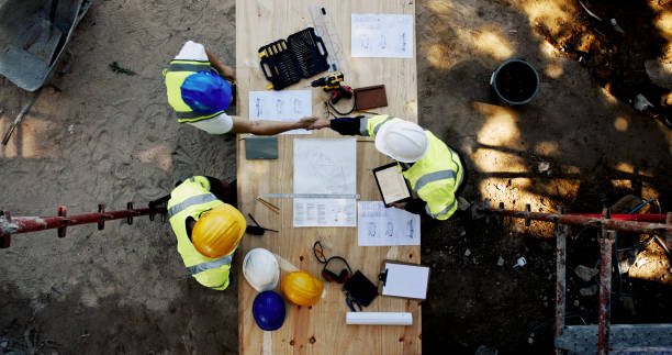 istock Blueprint, construction site and men at table with handshake, collaboration and agreement from above. Architect, project manager and contractor shaking hands with floor plan, team partnership or deal 2199351021