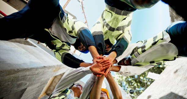 construction, teamwork and hands together on site for support with building inspection and compliance success. below, worker stack and people with celebration for project management and cooperation - byggarbetare bildbanksfoton och bilder