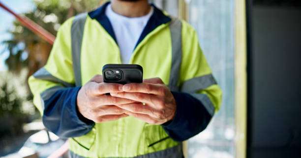 istock Hands, phone and construction worker with texting, person or contact with info for building development. Engineer, smartphone and check with network, notification or email on mobile app at property 2199351067