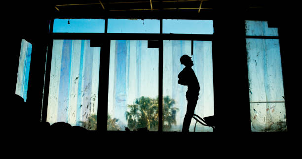 istock Silhouette, person and radio with construction site, tired and building development project. Employee, shadow and architecture with career ambition, engineering and renovation with fatigue or burnout 2199351080