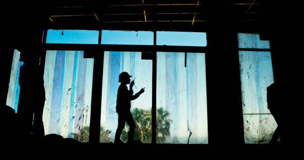 Silhouette, person and engineering with construction site, radio and building development project. Employee, shadow and architecture with career ambition, productivity and renovation with equipment