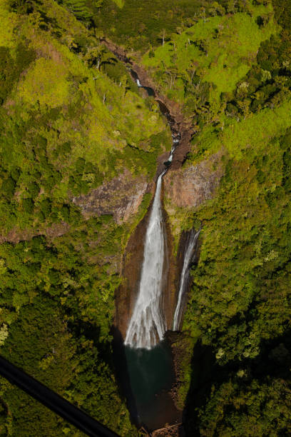 istock Manawaiopuna Falls, Waterfall Going through Bright Green Tropical Forest and Mountains from Helicopter View in Kauai Hawaii 2199351539