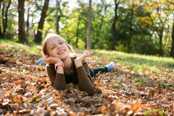 istock A girl is lying on the ground with an autumn leaf 2199352220