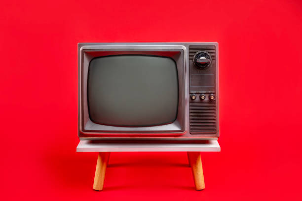 istock Retro red old television on a stand with blank screen, vintage analog old fashioned TV isolated on red background. 2199353076