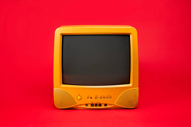 istock Old yellow television set with blank black screen Isolated on a red background 2199353092