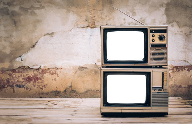 istock Two old retro televisions with blank white screens on old wall background, with copy space. 2199353285