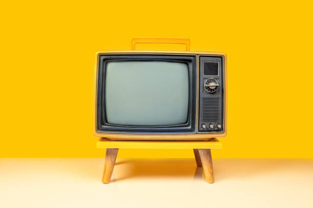 istock Front view of retro yellow old television on a stand with blank screen, vintage old fashioned TV isolated on yellow background with clipping path 2199353321