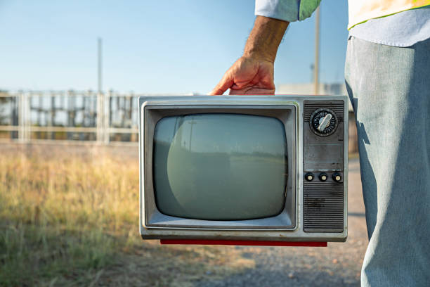 A man hold vintage old tv, outdoors, antique analog television set with blank screen