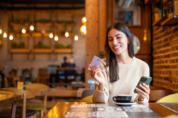 istock Confident young woman with credit card 2199353887