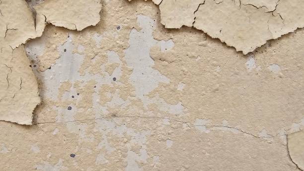 istock The yellow wall, whose paint has peeled off because it is old and exposed to rain and heat, needs to be repaired and repainted. Abstract background template. 2199356342