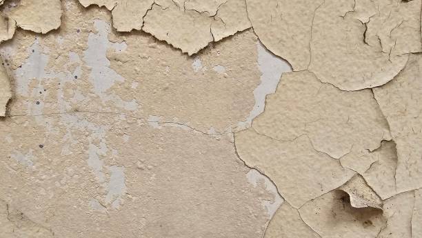 istock The yellow wall, whose paint has peeled off because it is old and exposed to rain and heat, needs to be repaired and repainted. Abstract background template. 2199356567