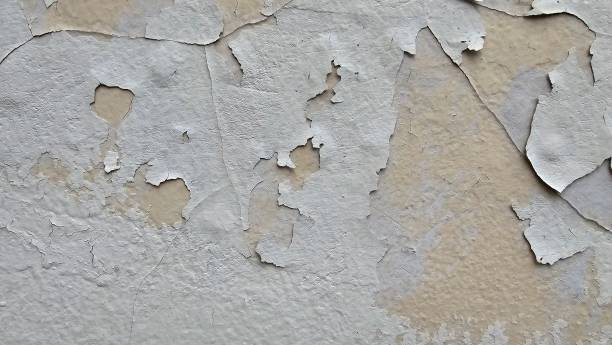 istock The yellow wall, whose paint has peeled off because it is old and exposed to rain and heat, needs to be repaired and repainted. Abstract background template. 2199356682