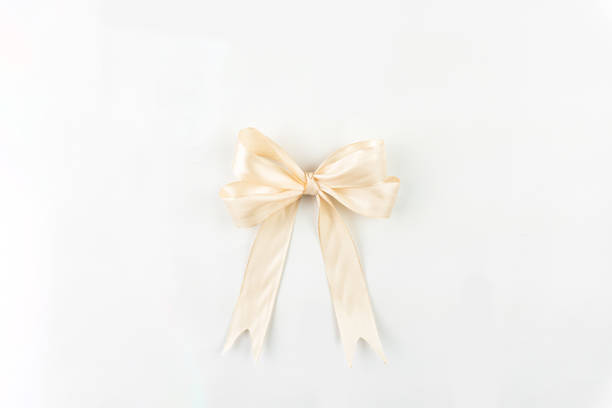 istock A subtle cream satin ribbon tied into a classic bow, presented against a pristine white setting, conveying understated elegance and sophistication. 2199356855