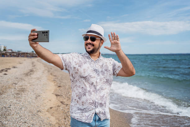 istock Man having a video call on the beach 2199357861
