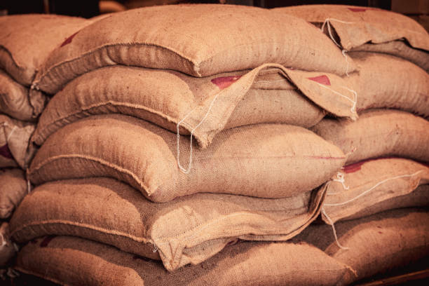 istock Vintage burlap sacks stacked in dimly lit warehouse. Rustic industrial storage for grains, coffee, spices in traditional textile packaging. Agricultural and trade concept 2199358030