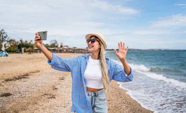 istock Woman having a video call on the beach 2199358178