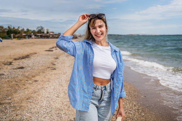 Young happy woman with arms outstretched enjoying a day on the beach