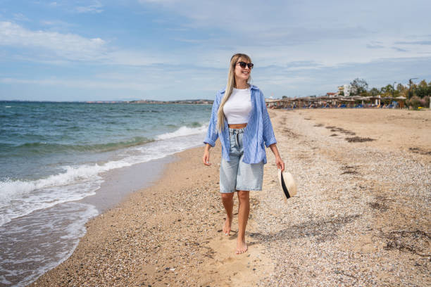 istock Woman walking on the beach 2199359228