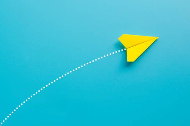 istock Top view of yellow paper airplane on blue background 2199360963