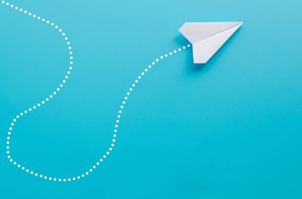 istock Top view of white paper airplane heading to different direction on blue background 2199360990