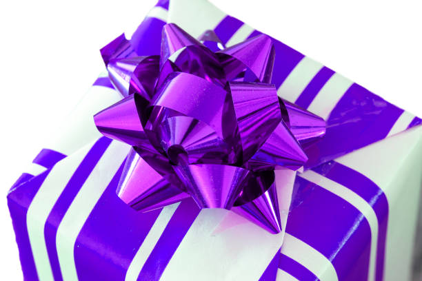 Gift wrapping, New Year's concept. Striped package and raffia ribbon. Isolated from background.