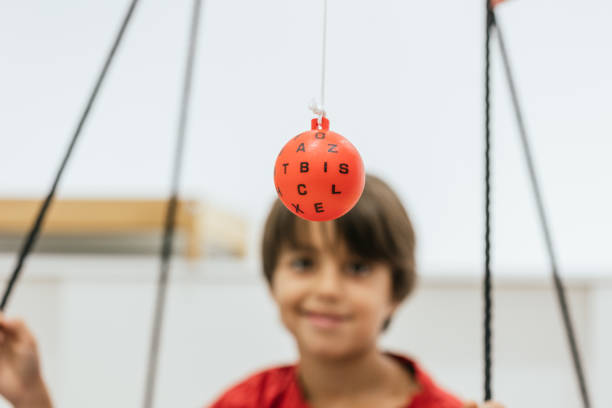 Boy focusing on a marsden ball during vision therapy session