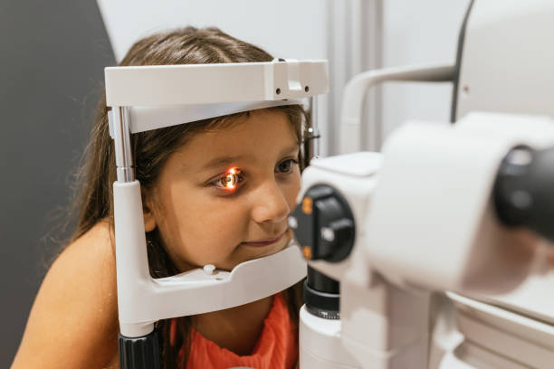 istock Young girl undergoing eye exam with phoropter in modern clinic 2199367789