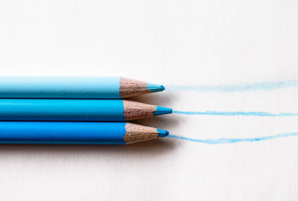 Three colored pencils in shades of blue, lines drawn on a white background