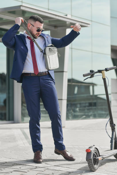istock Well Dressed Male Adjusting Laptop Bag Before Heading Home From Work on His Electric Scooter 2199371255