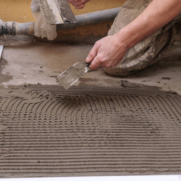 istock Construction worker applies cement for laying floor ceramic tiles with spatula 2199372126