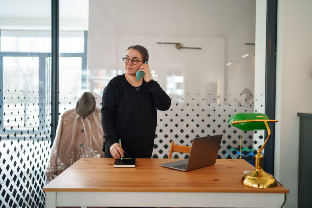 istock Woman talking on the mobile phone at the office. 2199372906