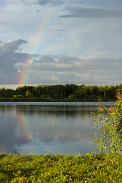istock Rainbow after rain on the lake shore 2199375216