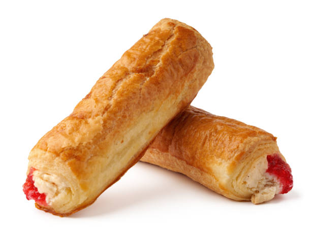istock Pastry rolls filled with sweet cream and cherry topping displayed on a white background 2199376372