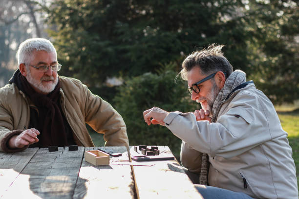 istock Pensioners play dominoes in the park 2199376486