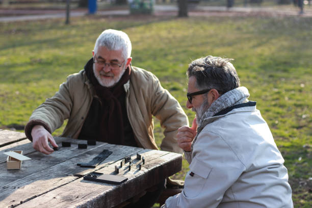 istock Pensioners play dominoes in the park 2199376515
