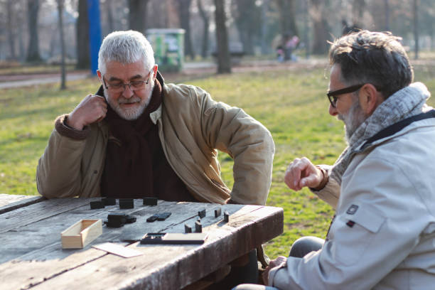 istock Pensioners play dominoes in the park 2199377132