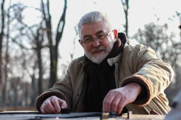istock Pensioners play dominoes in the park 2199377210