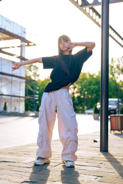 istock Young dancer showcases stylish moves in urban setting during sunset 2199378478