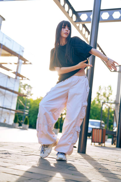 istock Urban dance performance at sunset featuring a dancer in stylish outfit showcasing vibrant energy and movement 2199378491
