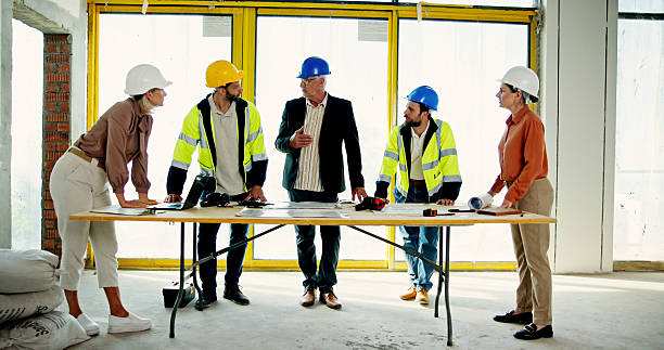 istock Architecture, contractor and blueprint with people on construction site for building, real estate and inspection. Engineer, planning and property developer with employee for teamwork and renovation 2199378816