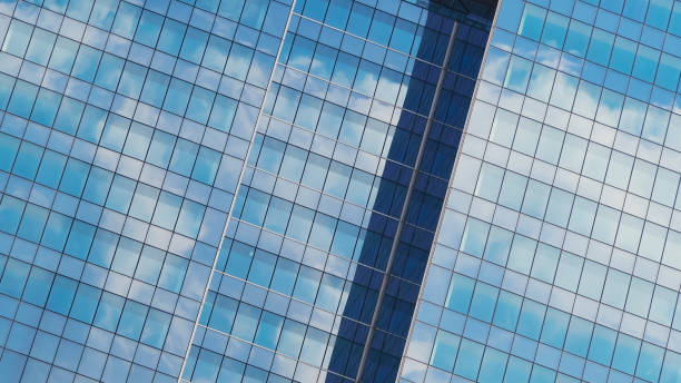 istock A sleek modern facade with reflective glass panels captures the sky's subtle clouds. The vertical alignment adds depth and elegance to the composition. 2199379036