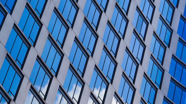 istock A dynamic diagonal pattern of reflective glass windows creates a sleek, modern aesthetic. The blue sky reflections add depth and contrast to the architecture. 2199379037